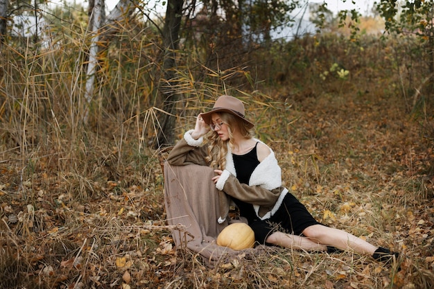 Girl in a cap with pumpkin fall in October