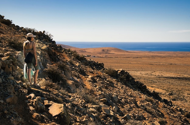 フェルテベントゥラ島のティンダヤ地域の美しい砂漠の風景を注意深く観察している女の子