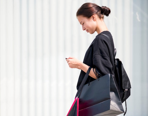 Ragazza che porta un sacco di borse della spesa