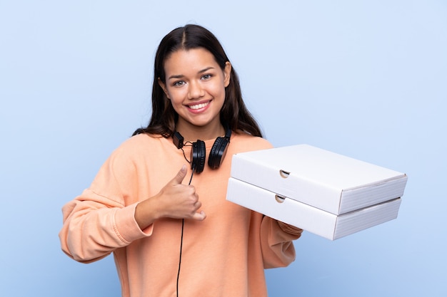 Girl catching pizza boxes over isolated wall