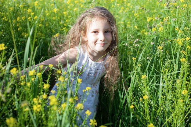 A girl of Caucasian appearance with long hair in green grass