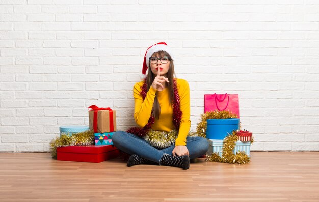 Girl celebrating the christmas holidays showing a sign of closing mouth and silence gesture