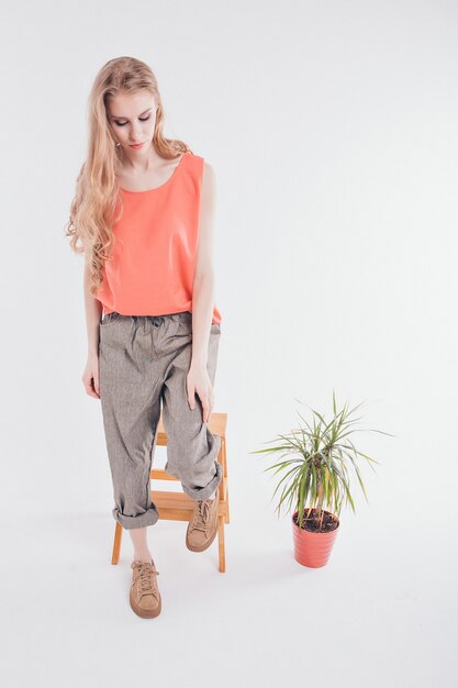 Girl on a chair next to a plant