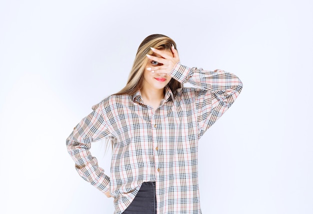 Girl in checked shirt looking across her fingers