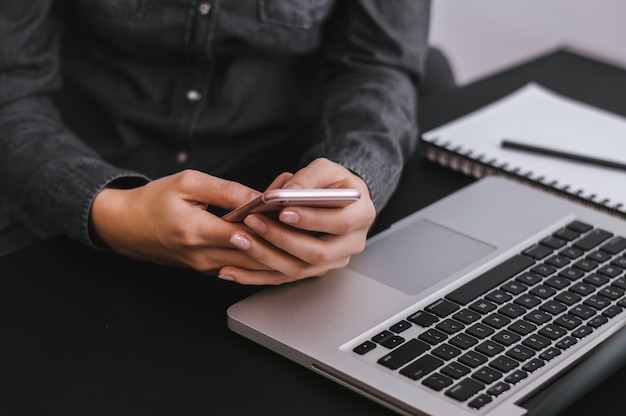 Photo girl checking her phone while working at home