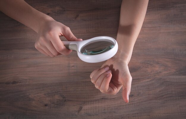 Girl checks nails with a magnifying glass