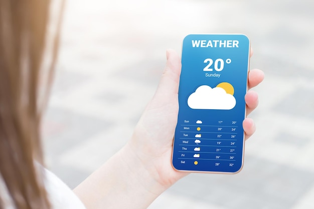 Foto la ragazza controlla le previsioni del tempo in un'applicazione mobile