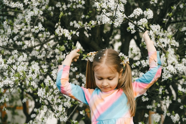 Girl under cherry blossom trees shaking the branches