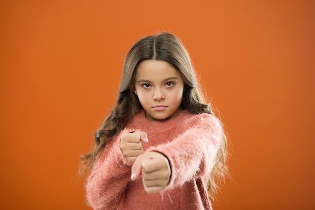 Girl child cute but strong. Self defense for kids. Defend Innocence. How teach kids to defend themselves. Self defense strategies kids can use against bullies. Girl hold fists ready attack or defend.