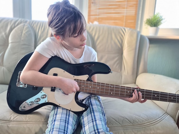 Girl child learns to play electric guitar Music training