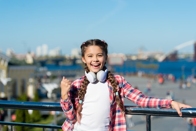 Girl child listen music outdoors with modern headphones Listen for free Stream music anywhere Get music family subscription Access to millions of songs Best music apps that deserve a listen