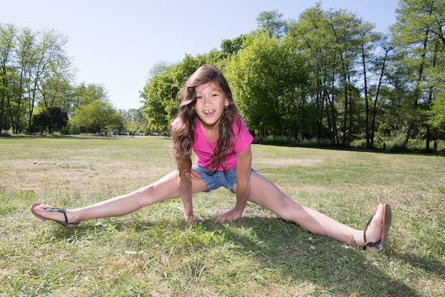 Girl child plays to do gymnastics in the park