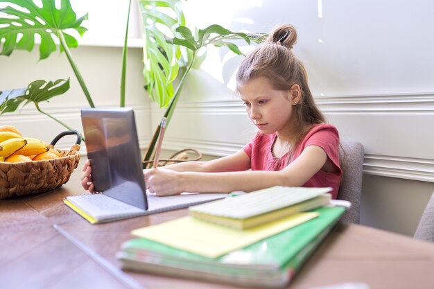 Girl child studying at home using digital tablet. Distance learning, online lesson, video conference, school lessons in electronic form. Modern school, technology, education, children concept.