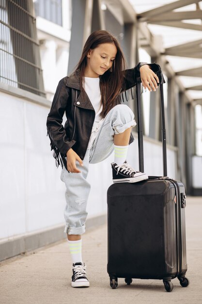 Photo girl child with luggage at the terminal