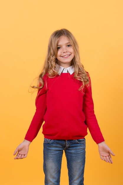 Girl child with smile in red sweater and blue jeans