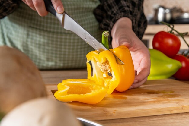 girl chopping the yellow pepper , home cooking food, kitchen background