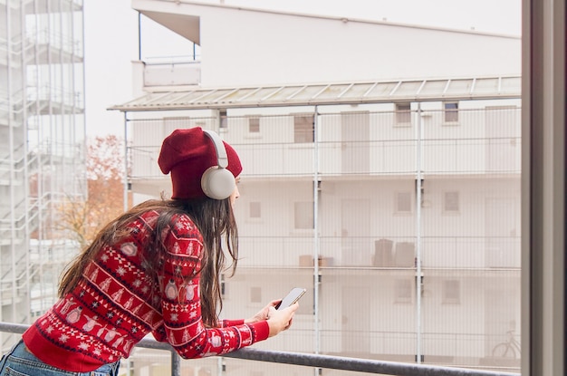 音楽を聴いているクリスマスの服を着た女の子。電話で話している女性