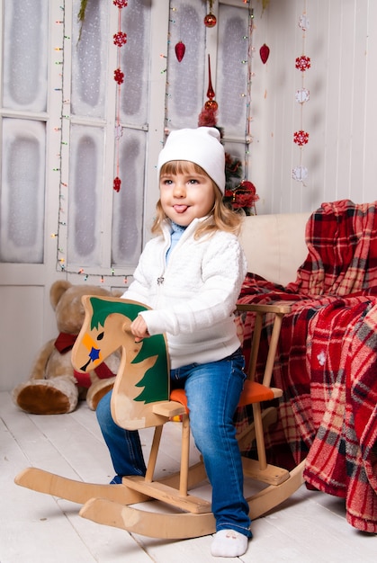 Girl in Christmas day with horse toy