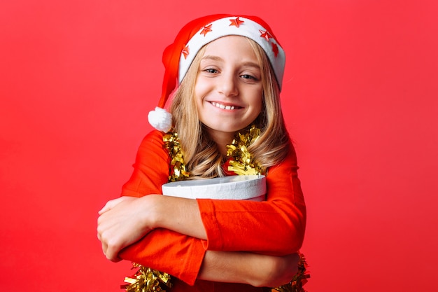 A girl in a christmas hat and with tinsel on her neck
