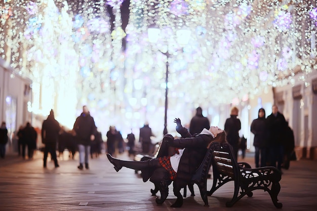 女の子のクリスマス ライトの夜の装飾された都市、都市の装飾と花輪、夜の街の明かりの背景に若いモデル