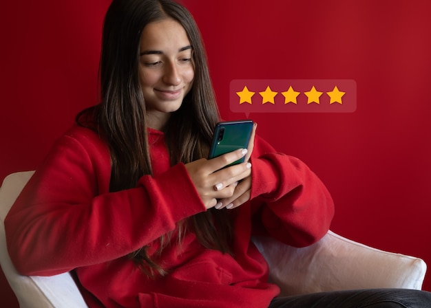 Photo girl christmas shopping on smartphone submitting 5 gold star satisfaction feedback