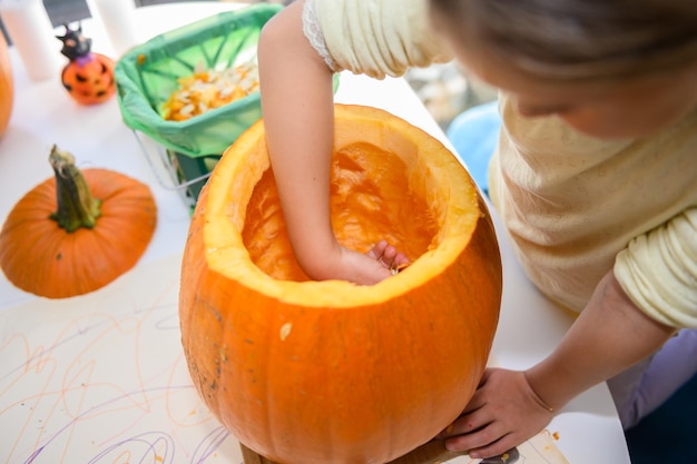 写真 ハロウィーンのカボチャを掃除する女の子