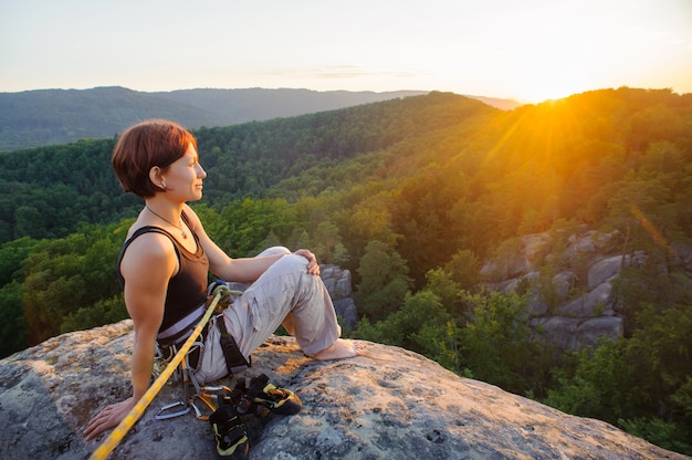 Girl climber on mountain peak on high altitude in evening