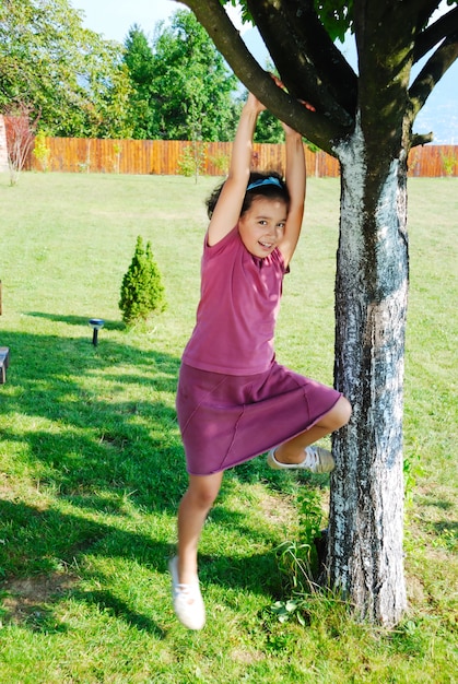 Ragazza arrampicata su albero e giocando