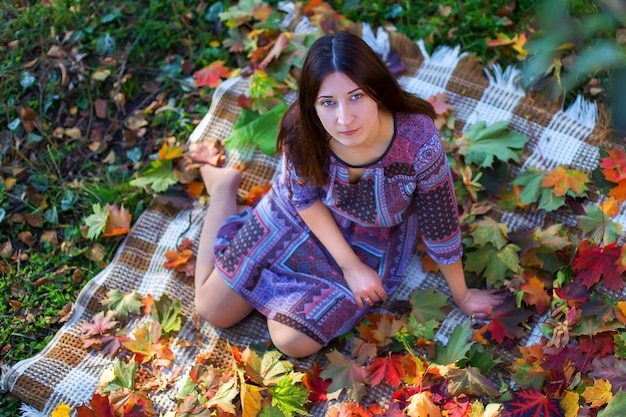 The girl close up in autumn foliage