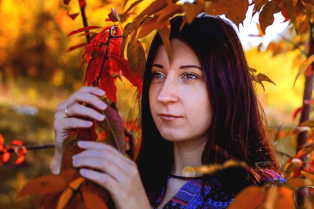 The girl close up in autumn foliage