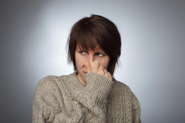 Girl closes the nose because of bad smell or stink