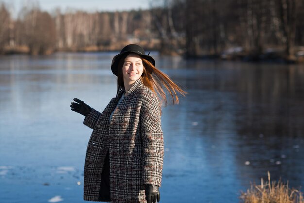 A girl in a coat on the background of snow in spring 3482