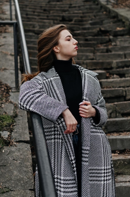 a girl in a coat near the stairs