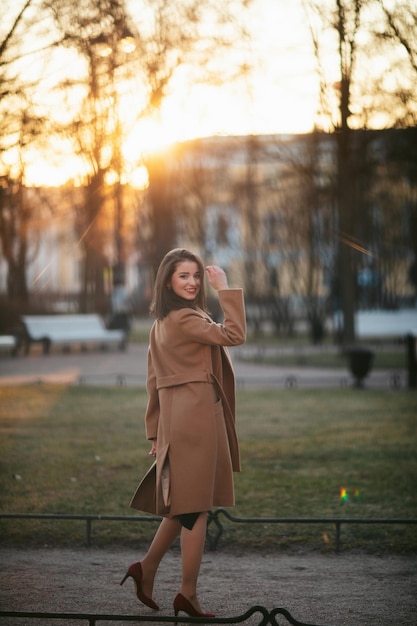 Girl in coat in the street at sunrise