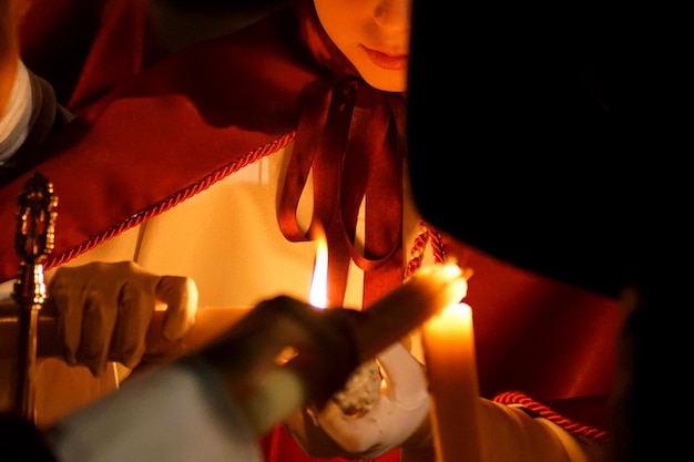 Photo a girl collecting wax from a nazarene candle