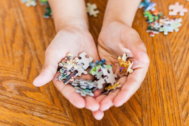 The girl collects pieces of them to make a picture, puzzles, mind development, skills, understanding, playing, spending time, communicating with parents, mom