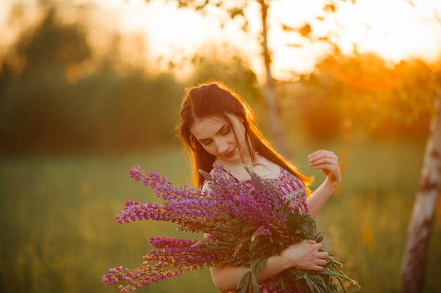 Girl in a colored dress. Holds flowers in her hands