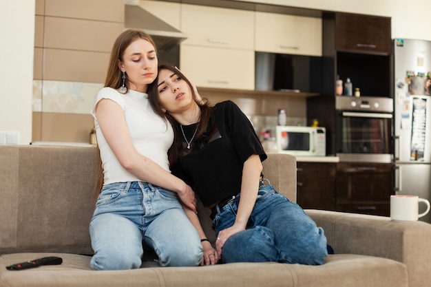 Girl comforting her best friend while sitting on the couch