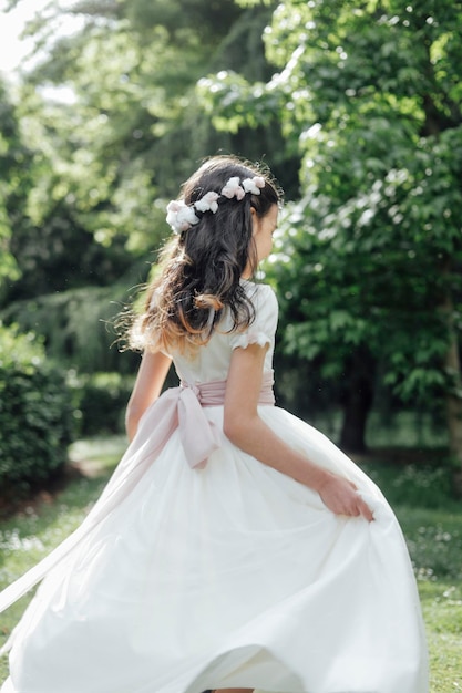 Girl in communion dress dancing in the open air