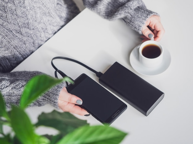 The girl connected her smartphone to the power bank.