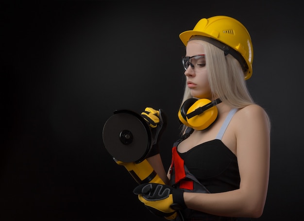 Girl in a construction firm works with a tape measure