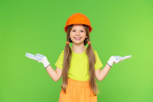 A girl and a construction protective helmet. Construction and renovation in the premises. Green isolated background. Copy space.