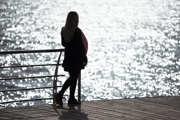 Girl contemplate the sunlight glare in the sea