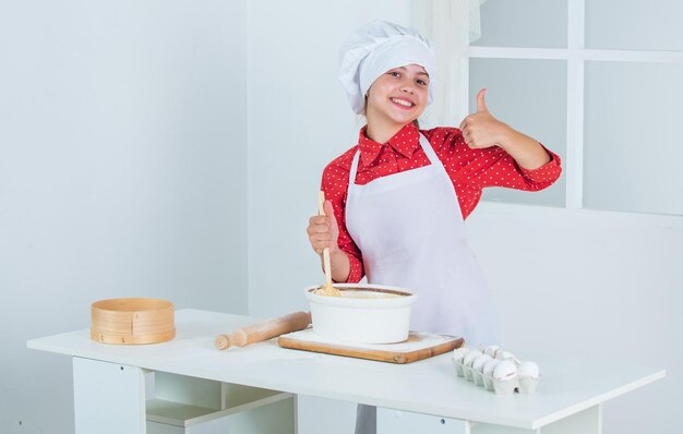 女の子は夕食のベーキングのために何かを調理します