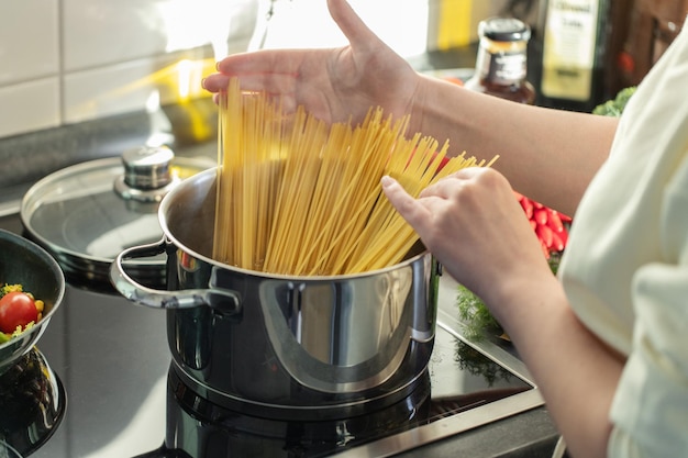 girl cooking pasta spaghetti in pot