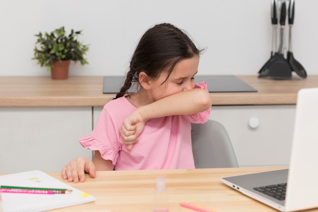 Photo girl coughing in elbow