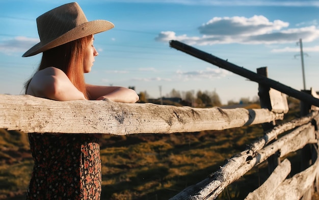 Girl in a cowboy hat at the fence