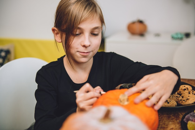 Foto ragazza che crea jack-o-lantern