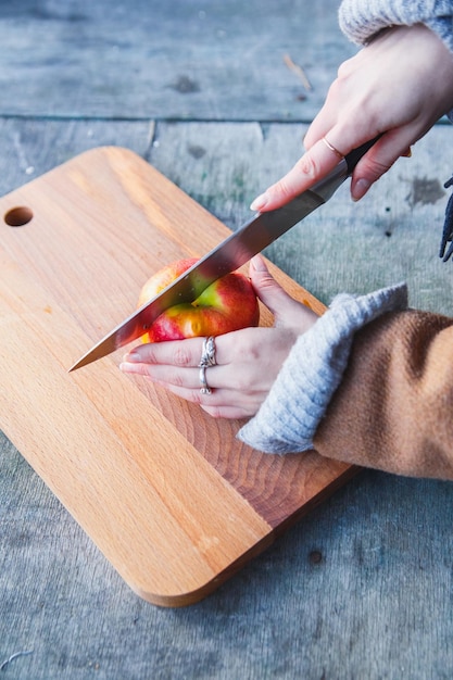 Girl cuts an apple in the forest