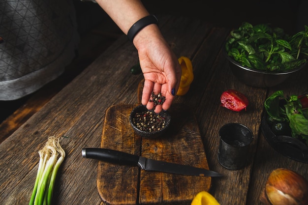 Foto ragazza che taglia le verdure su una tavola di legno